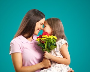 Happy Mother and daughter together with flowers