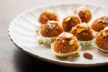 Carrot Halwa Laddu or sweet balls,  served in a plate with dry fruits toppings. selective focus