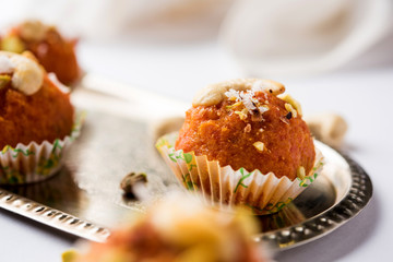 Carrot Halwa Laddu or sweet balls,  served in a plate with dry fruits toppings. selective focus