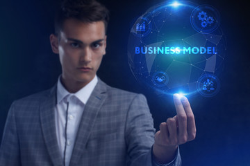 The concept of business, technology, the Internet and the network. A young entrepreneur working on a virtual screen of the future and sees the inscription: Business model