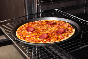 Cooking homemade pizza in an electric oven.