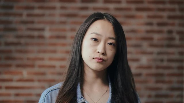 Portrait of young asian girl nods her head negatively. showing indignation