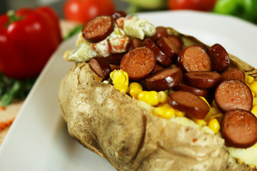 Kumpir - Turkish baked potato with butter, cheese, corn, beef sausage, vegetable salad and spices. This kumpir is traditional turkish food isolated on white background