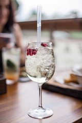 Fresh summer cocktails with bubbles, lime, mint and red berries are on the table at the sunset. Atmospheric summer drinks close up. Belarus, Minsk