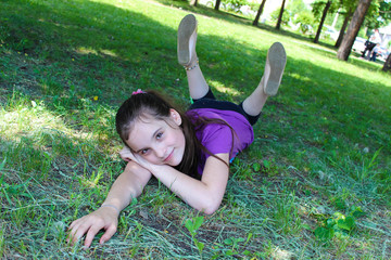 Smiling girl lying on the grass in the Park on a Sunny day