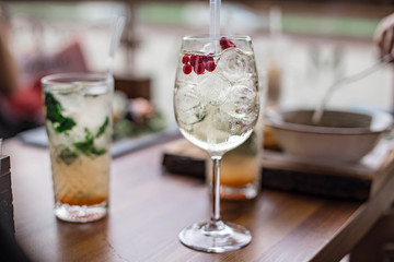 Fresh summer cocktails with bubbles, lime, mint and red berries are on the table at the sunset. Atmospheric summer drinks close up. Belarus, Minsk
