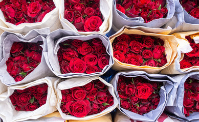 Collection of several bouquets of fresh red rose flowers in a flower market