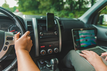 couple in car. man working on laptop in road trip. lifestyle concept