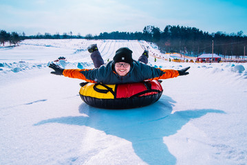 man snow tubing from hill. winter activity concept