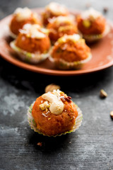Carrot Halwa Laddu or sweet balls,  served in a plate with dry fruits toppings. selective focus