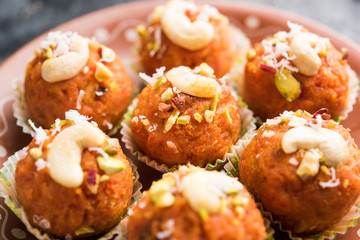 Carrot Halwa Laddu or sweet balls,  served in a plate with dry fruits toppings. selective focus