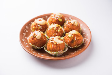 Carrot Halwa Laddu or sweet balls,  served in a plate with dry fruits toppings. selective focus