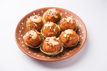 Carrot Halwa Laddu or sweet balls,  served in a plate with dry fruits toppings. selective focus