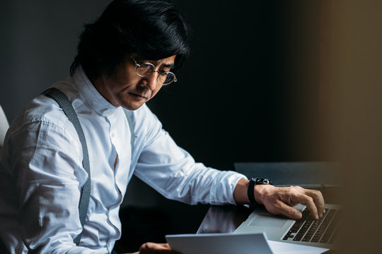 Serious middle-aged Asian businessman working.