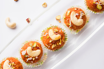 Carrot Halwa Laddu or sweet balls,  served in a plate with dry fruits toppings. selective focus