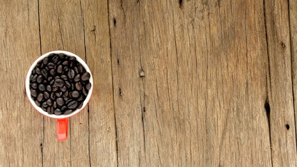 coffee beans in ceramic cup on old wood desk at kitchen room