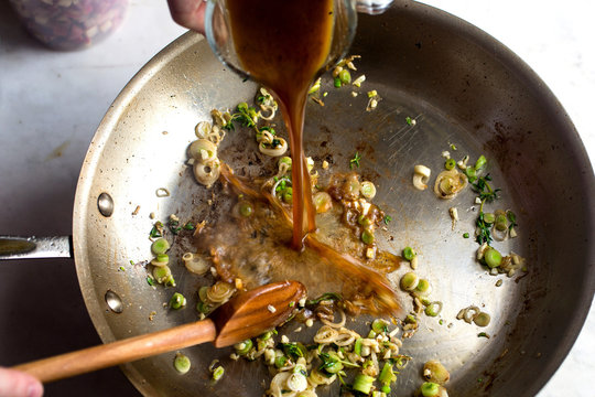Overhead view of stock pouring in frying pan 