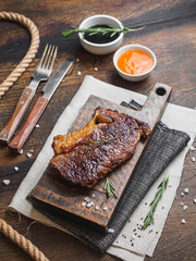 Ribeye stake with spices on the wooden board