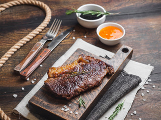 Ribeye stake with spices on the wooden board