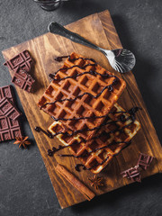 Belgian waffles with chocolate on wooden board