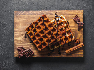 Belgian waffles with chocolate on wooden board