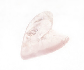 polished rose quartz stone in heart shape on white