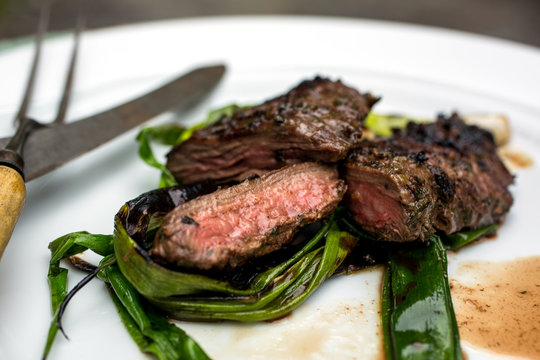 Close up of grilled skirt steak with garlic and herbs served on plate
