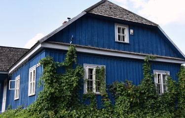 Traditionelles, dunkelblaues Holzhaus mit weißen Fenstern in Trakai
