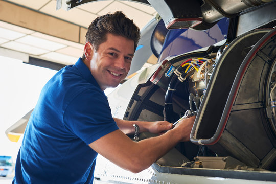 Portrait Of Male Aero Engineer Working On Helicopter In Hangar