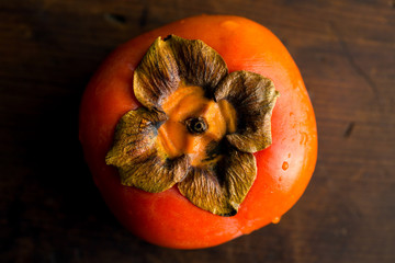 Overhead view of persimmon fruit on wooden table