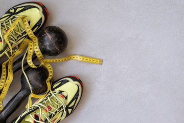 Sneakers, old dumbbells and tape measure, top view, concept of healthy lifestyle. Sports background, copy space