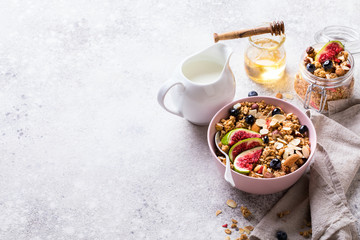 Muesli with Nuts Yogurt and fresh Figs Blueberry on the gray Background.Granola Healthy Breakfast. Sweet food Dessert. Snack  Dry Diet Nutrition Concept.Copy space for Text