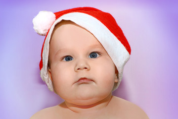 Portrait of a cute baby in a christmas hat, facial expression and emotions