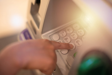 Woman is close up of hand, finger pressing keystroke cash machine, ATM banking Located in front of...