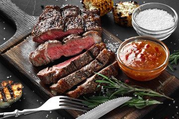 Sliced grilled medium rare beef steak served on wooden board Barbecue, bbq meat beef tenderloin.