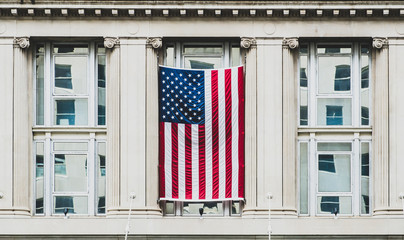 Washington DC, exterior view of a neoclassical government building with the flag of the United...
