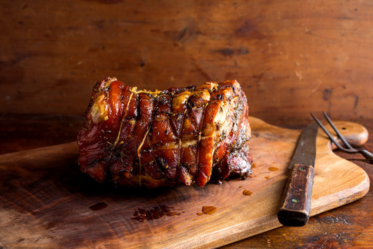 Close up of roast porchetta pork on cutting board