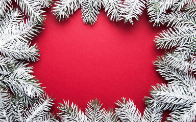 Merry Christmas and Happy Holidays greeting card, frame, banner. New Year. Noel. Silver, white and red Christmas ornaments and fir tree on red background top view. Winter holiday xmas theme. Flat lay.