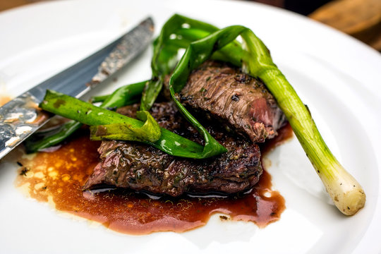 Close up of grilled skirt steak with garlic and herbs served on plate