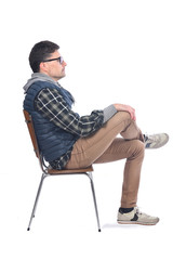 portrait of a man sitting on a chair legs and arms crossed looking to the side