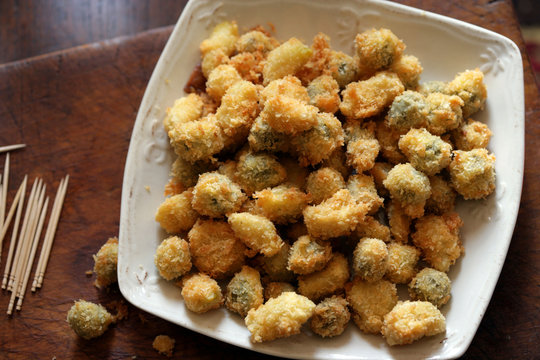 Close up of deep fried garlic Cloves and olives

