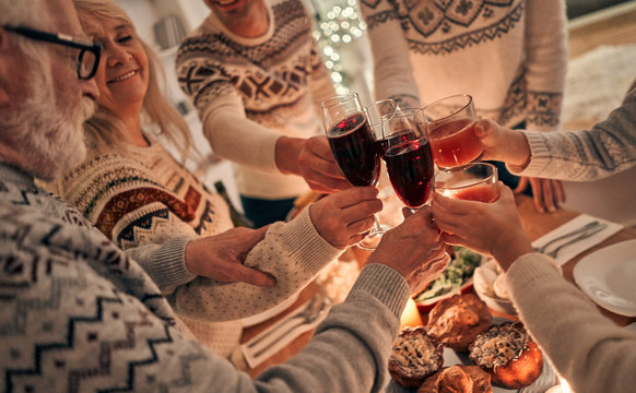 The happy family clink glasses above the christmas table