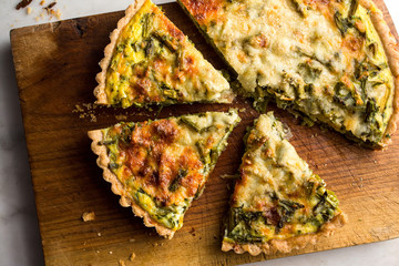 Close up of roasted asparagus and scallion quiche slices on cutting board