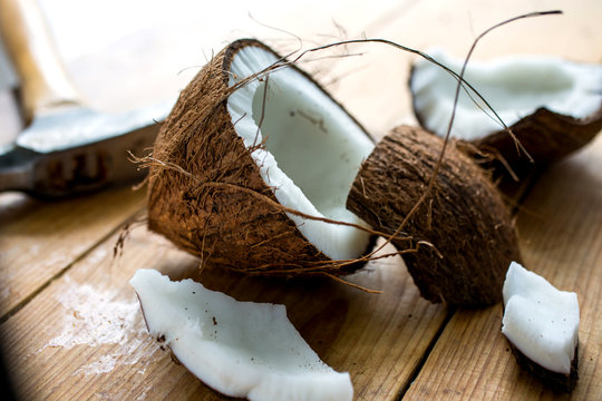Close up of broken coconut on wooden table - Powered by Adobe