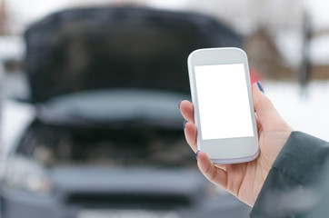 Evacuation call concept.Mobile phone with blank screen on on broken car background. Call to a car mechanic.
