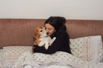 young woman embraces her Beagle dog