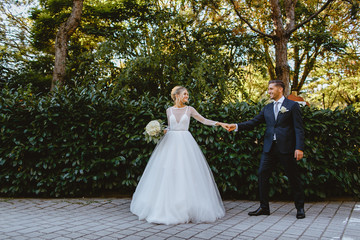Bride and groom walk through the park in the city of Ravenna.