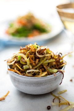 Close up of quinoa and roasted carrot salad with frizzled leeks in bowl