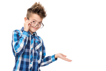 Cute smiling boy wearing reading glasses and pointing with hand to one side studio portrait on white background.