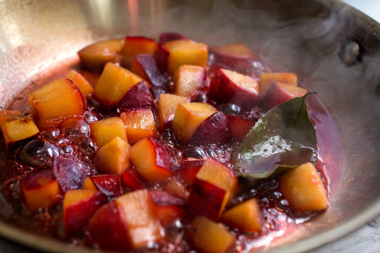 Close up of plum cooking in saucepan